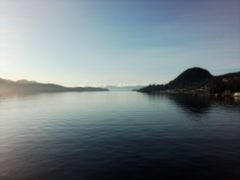 From an ocean looking between two islands with sunshine beyond the left.